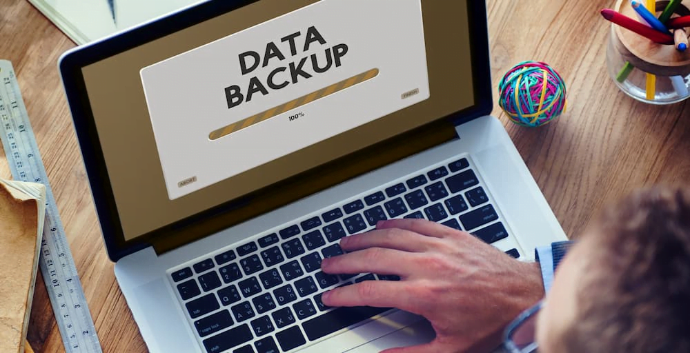 Man behind laptop making a backup of his data