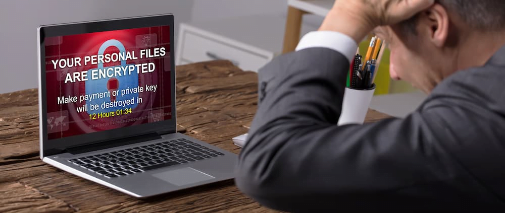 Man looking frustrated at hacked laptop